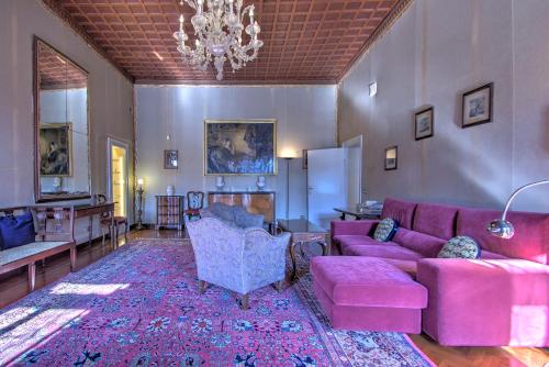 a living room with a pink couch and a chandelier at RABOSO Grand 9-windows in Venice