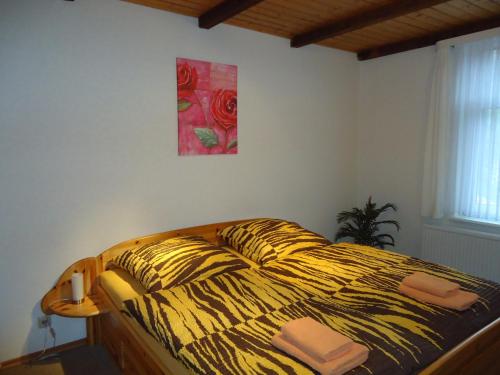 a bedroom with a bed with a yellow and black comforter at Pension Thaler Hof in Thale