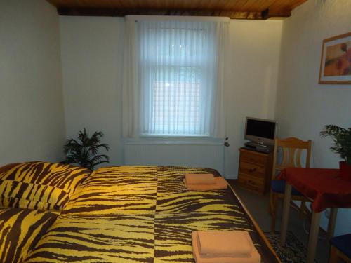 a bedroom with a bed and a window and a table at Pension Thaler Hof in Thale