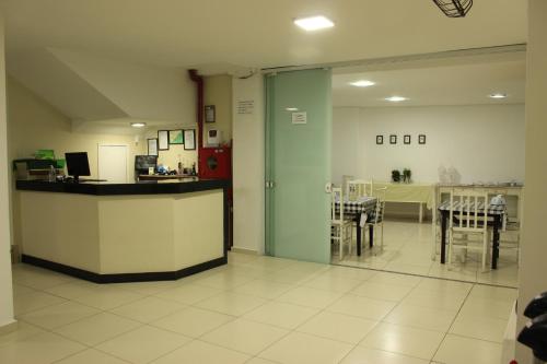 un restaurante con barra, mesas y sillas en Novo Hotel Douglas, en Balneário Camboriú