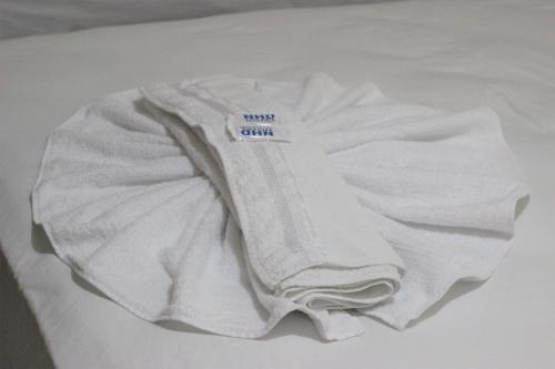 una camisa blanca sentada en la parte superior de una cama en Novo Hotel Douglas, en Balneário Camboriú