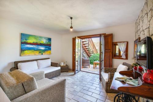 a living room with a couch and a tv at Alacati Kapari Hotel - Special Category in Alacati