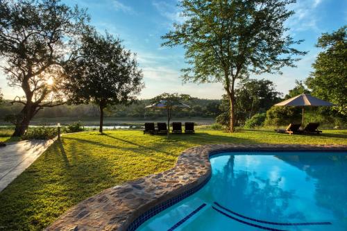 a swimming pool in the backyard of a house at Emhosheni River Lodge in Balule Game Reserve