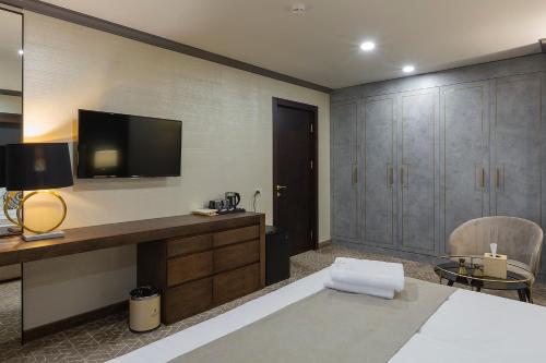 a bedroom with a bed and a tv on the wall at Jermuk Hotel and SPA in Jermuk