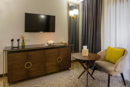 a hotel room with a tv and a chair and a table at Jermuk Hotel and SPA in Jermuk