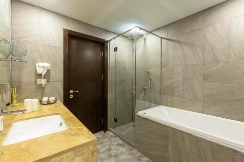 a bathroom with a tub and a sink and a shower at Jermuk Hotel and SPA in Jermuk