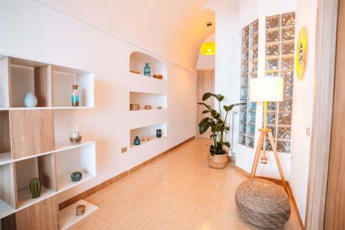 a hallway with white shelves and a potted plant at CASA CHIARINA breathtaking sea view in Ravello
