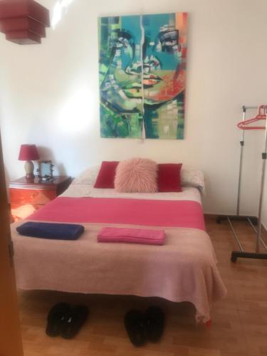 ラスパルマス・デ・グランカナリアにあるTranquila habitaciónのベッドルーム1室(壁に絵画が描かれたベッド1台付)