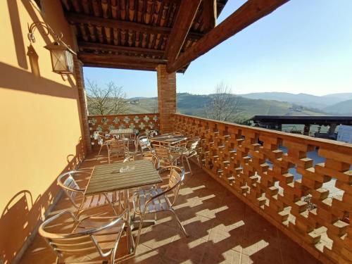 un patio con mesas y sillas en el balcón en Agriturismo Vecchio Torchio, en Canelli