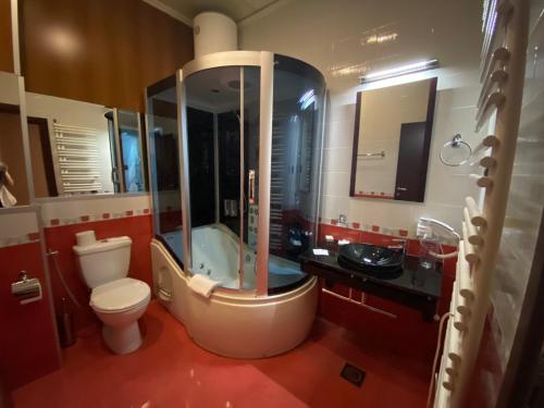 a bathroom with a shower and a toilet and a sink at Hotel Fortuna in Banja Luka