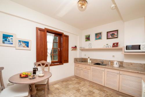 a kitchen with a table and a small table with fruit on it at Alacati Kapari Hotel - Special Category in Alacati