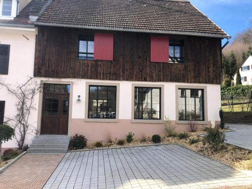 une maison avec des fenêtres à volets rouges et une allée dans l'établissement Gîte du Fronzell, à Luttenbach-près-Munster