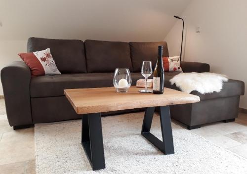 a living room with a couch and a table with wine glasses at Landhof Sedlmair in Gilching