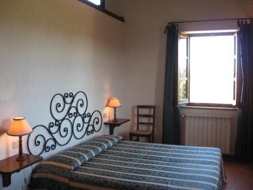 a bedroom with a bed and a window at Agriturismo Chieteno con piscina e AC- Cetona in Cetona