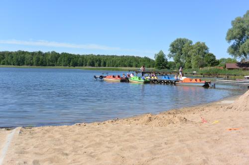 people on boats in the water near a beach at Letnisko Zalesie in Rentyny