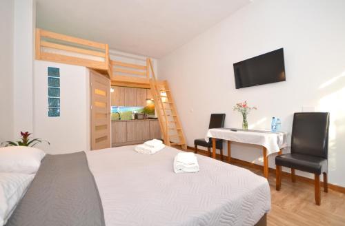 a bedroom with a bed and a desk and a table at Apartamenty Plażowa 11 in Darłówko
