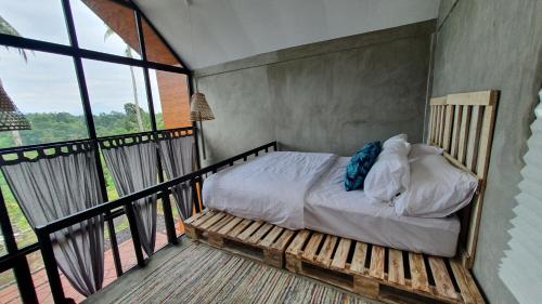 1 dormitorio con 1 cama en el balcón en Hara Bali Eco Homestay, en Balian