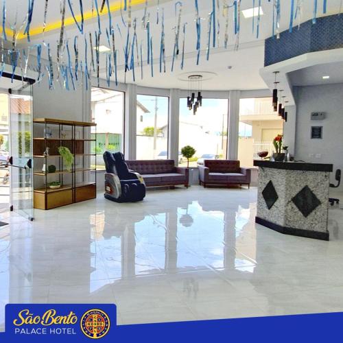 a lobby with a room with a couch and chairs at São Bento Palace Hotel in Aparecida