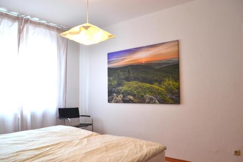 1 dormitorio con una pintura colgada en la pared en Ciao - Wohnen charmant & zentral in Weiden en Weiden