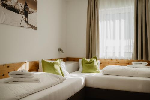 two white beds in a room with a window at Appartements Almnest in Schladming
