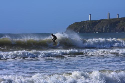 a person riding a wave on a surfboard in the ocean at Beach Haven Apartments in Tramore