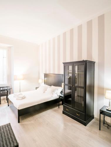 a bedroom with a bed and a black cabinet at Piazza Cavour Suite in Rome