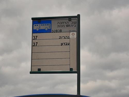a sign for a bus stop with a bus at Country lodging in Manot in Manot