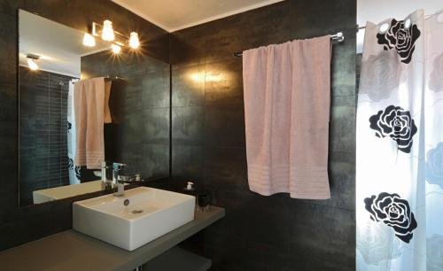 a bathroom with a white sink and a mirror at Anima Apartments in Chora Folegandros