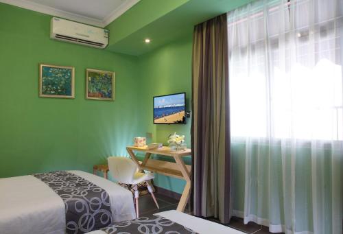 a room with two beds and a desk and a window at Care Hotel Coast Collection in Sanya