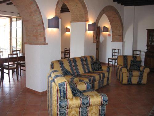 a living room with two couches and a table and chairs at Agriturismo Chieteno con piscina e AC- Cetona in Cetona
