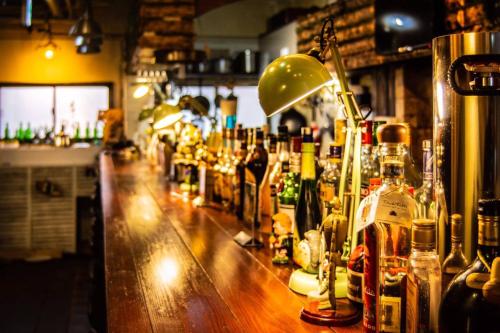 a bar with a lot of bottles of alcohol at Takamatsu Guesthouse BJ Station in Takamatsu