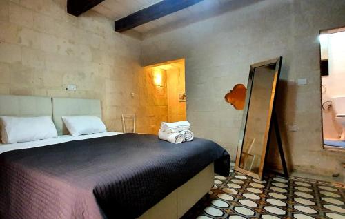 a bedroom with a bed with towels on it at Valletta Lucia Townhouse in Valletta