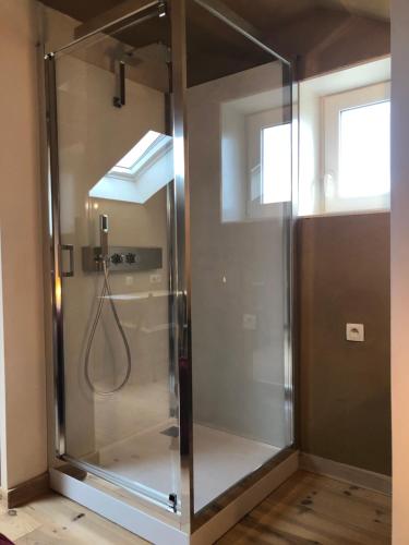 a shower with a glass door in a room at B&B Leybeeckhof in Holsbeek