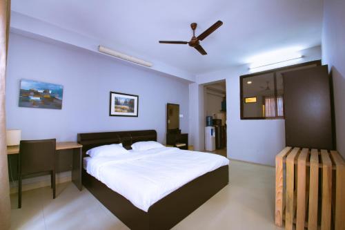 パタンにあるThe Pines Serviced Residenceのベッドルーム1室(ベッド1台、デスク、シーリングファン付)