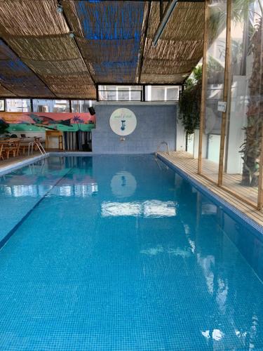 a large blue swimming pool with a clock on the wall at Hamra Urban Gardens in Beirut