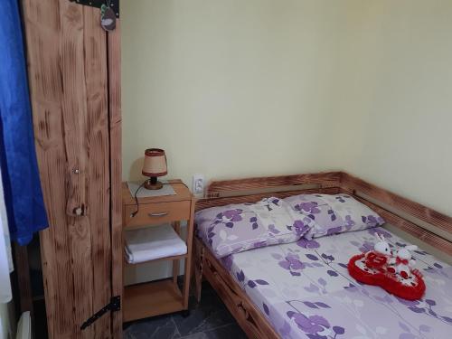a bedroom with a bed and a table with a lamp at SubotićSmještaj in Kulaši
