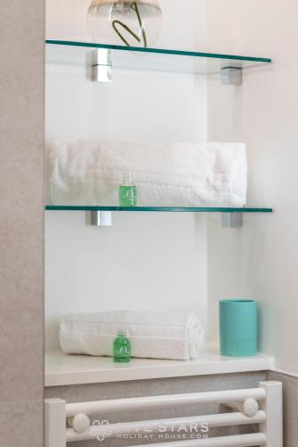 - une salle de bains pourvue de serviettes blanches sur une étagère dans l'établissement Suite Versailles Five Stars Holiday House, à Nice