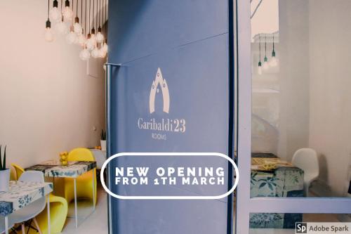 a sign on the door of a new opening from market at Garibaldi23 Rooms in La Spezia