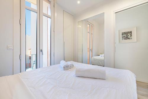 a white bedroom with a large bed with two towels on it at Suite Versailles Five Stars Holiday House in Nice