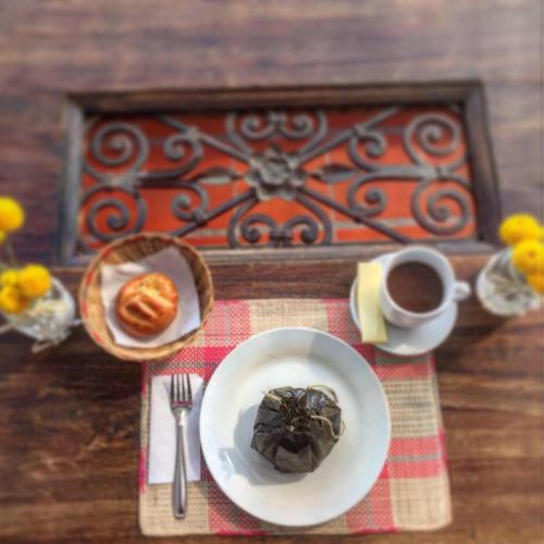 a table with a plate of food and a cup of coffee at Hotel Casa Floralia in Tibasosa