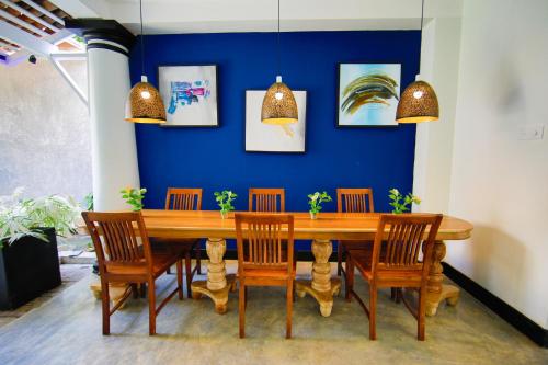 uma sala de jantar com uma mesa de madeira e cadeiras em Parawa House em Galle