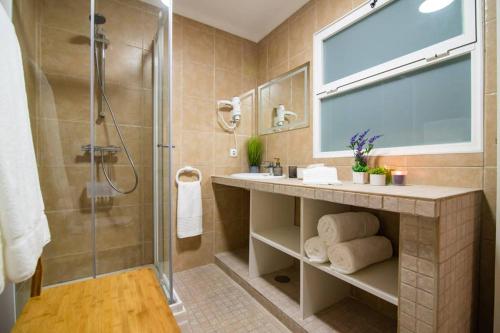 uma casa de banho com um chuveiro, um lavatório e uma cabina de duche em vidro. em CASA XAVIER - PISCINA 2735/AL em Ponta Delgada