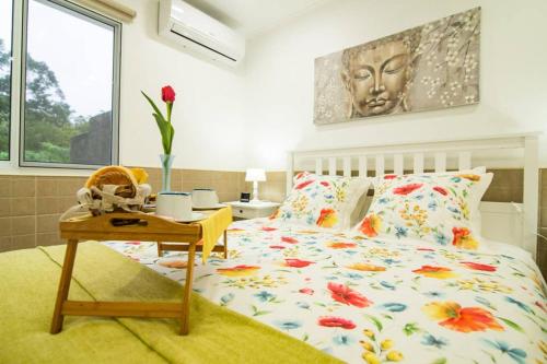 a bedroom with a bed and a table with a vase on it at CASA XAVIER - PISCINA 2735/AL in Ponta Delgada