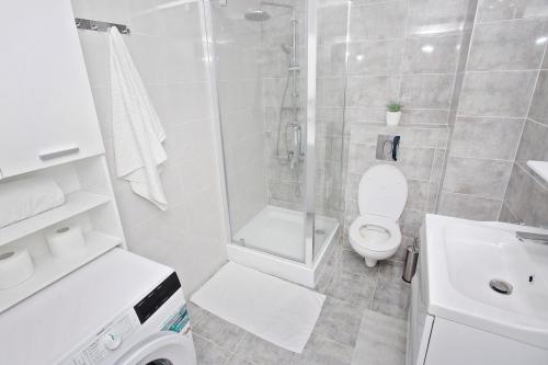 オラデアにあるPanoramic Studio Oradeaのシャワーとトイレ付きの白いバスルーム