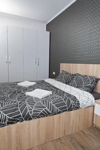 a bedroom with a bed with a black and white comforter at Panoramic Studio Oradea in Oradea