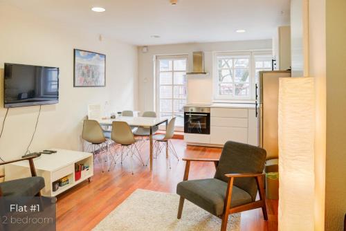 une cuisine et un salon avec une table et des chaises dans l'établissement Dandelion Apartments Lāčplēša, à Riga