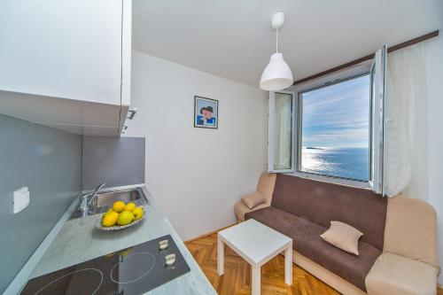 a small living room with a couch and a table at Apartment Residence Narona in Mlini