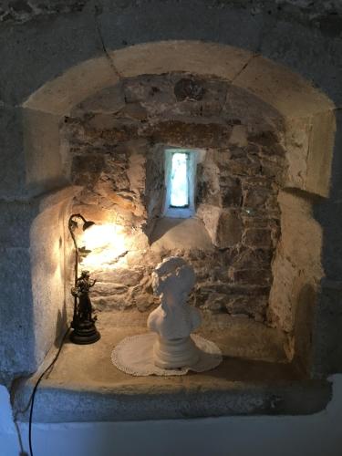 a statue in a stone room with a window at Chateau Mareuil in Brigueuil-le-Chantre