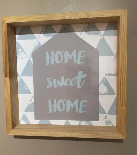 a sign that says home sweet home in a window at Le Compostelle de Conques in Conques-en-Rouergue