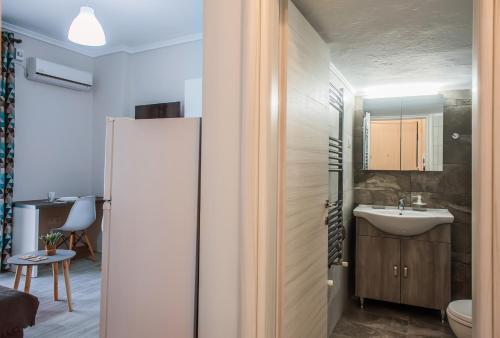 a small bathroom with a sink and a refrigerator at Freesia #colony_Urban_apartment in Thessaloniki
